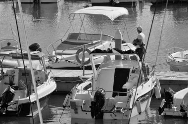 İtalya, Sicilya, Akdeniz, Marina di Ragusa (Ragusa ili); 9 Kasım 2024, limandaki insanlar, motorlu tekneler ve lüks yatlar - EDITORIAL