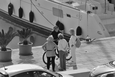 İtalya, Sicilya, Akdeniz, Marina di Ragusa (Ragusa Eyaleti); 21 Kasım 2024, limanda insanlar ve bir katamaran yelkenli teknesi - EDITORIAL