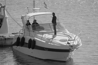 İtalya, Sicilya, Akdeniz, Marina di Ragusa (Ragusa Eyaleti); 24 Kasım 2024, limanda lüks bir yatta erkekler - EDITORIAL