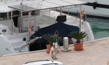 İtalya, Sicilya, Akdeniz, Marina di Ragusa (Ragusa Eyaleti); 26 Kasım 2024, limanda insanlar ve katamaran yelkenli tekneleri - EDITORIAL