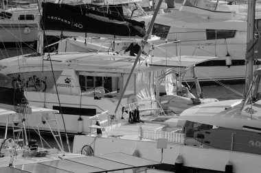 İtalya, Sicilya, Akdeniz, Marina di Ragusa (Ragusa Eyaleti); 27 Kasım 2024, limandaki bir katamaran yelkenli teknesinde adam - EDITORIAL