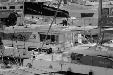 İtalya, Sicilya, Akdeniz, Marina di Ragusa (Ragusa Eyaleti); 27 Kasım 2024, limandaki bir katamaran yelkenli teknesinde adam - EDITORIAL