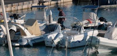 İtalya, Sicilya, Akdeniz, Marina di Ragusa (Ragusa Eyaleti); 2 Aralık 2024, limandaki insanlar, motorlu tekneler ve lüks yatlar - EDITORIAL