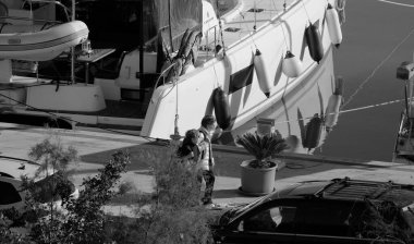 İtalya, Sicilya, Akdeniz, Marina di Ragusa (Ragusa Eyaleti); 11 Aralık 2024, limanda insanlar ve katamaran yelkenli tekneleri - EDITORIAL