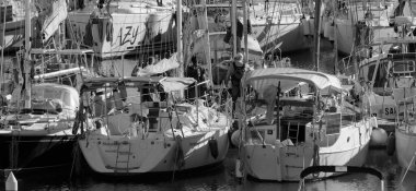 İtalya, Sicilya, Akdeniz, Marina di Ragusa (Ragusa ili); 18 Aralık 2024, limandaki insanlar ve yelkenliler - EDITORIAL