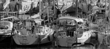 İtalya, Sicilya, Akdeniz, Marina di Ragusa (Ragusa ili); 18 Aralık 2024, limandaki insanlar ve yelkenliler - EDITORIAL