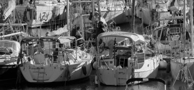 İtalya, Sicilya, Akdeniz, Marina di Ragusa (Ragusa ili); 18 Aralık 2024, limandaki insanlar ve yelkenliler - EDITORIAL