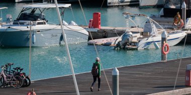 İtalya, Sicilya, Akdeniz, Marina di Ragusa (Ragusa ili); 21 Aralık 2024, limanda kadın ve lüks yatlar - EDITORIAL