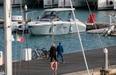 İtalya, Sicilya, Akdeniz, Marina di Ragusa (Ragusa Eyaleti); 10 Ocak 2025, limandaki insanlar, motorlu tekneler ve lüks yatlar - EDITORIAL