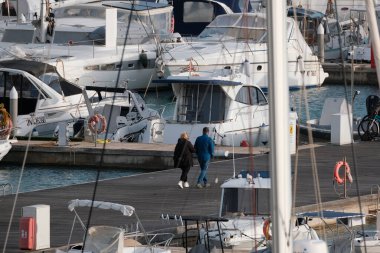 İtalya, Sicilya, Akdeniz, Marina di Ragusa (Ragusa Eyaleti); 10 Ocak 2025, limandaki insanlar, motorlu tekneler ve lüks yatlar - EDITORIAL