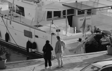 İtalya, Sicilya, Akdeniz, Marina di Ragusa (Ragusa ili); 12 Ocak 2025, çift ve limanda bir katamaran yelkenli teknesi - EDITORIAL