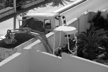 İtalya, Sicilya; Marina di Ragusa (Ragusa Eyaleti); 20 Ocak 2025, özel bir kazançta buldozer üzerinde çalışan adam - EDITORIAL