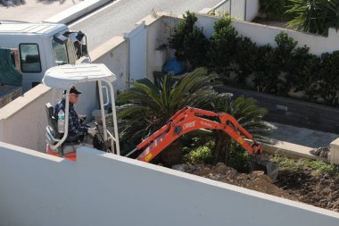 İtalya, Sicilya; Marina di Ragusa (Ragusa Eyaleti); 20 Ocak 2025, özel bir kazançta buldozer üzerinde çalışan adam - EDITORIAL