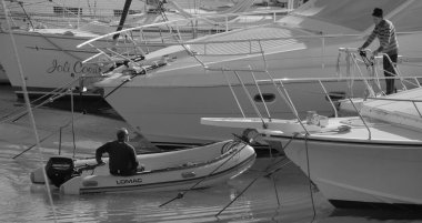 İtalya, Sicilya, Akdeniz, Marina di Ragusa (Ragusa Eyaleti); 4 Şubat 2025, limandaki insanlar, motorlu tekneler ve lüks yatlar - EDITORIAL