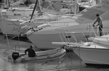 İtalya, Sicilya, Akdeniz, Marina di Ragusa (Ragusa Eyaleti); 4 Şubat 2025, limandaki insanlar, motorlu tekneler ve lüks yatlar - EDITORIAL