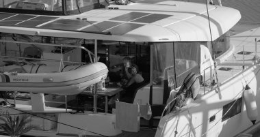 İtalya, Sicilya, Akdeniz, Marina di Ragusa (Ragusa Eyaleti); 4 Şubat 2025, limanda bir katamaran yelkenli teknesinde çift