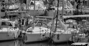 İtalya, Sicilya, Akdeniz, Marina di Ragusa (Ragusa Eyaleti); 19 Şubat 2025, limanda insanlar ve yelkenliler - EDITORIAL