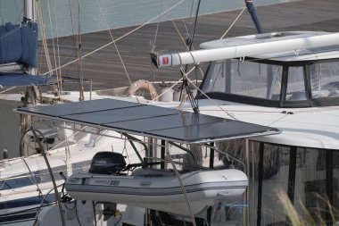 İtalya, Sicilya, Akdeniz, Marina di Ragusa (Ragusa Eyaleti); 22 Şubat 2025, limandaki bir katamaran yelkenli teknesinin fotovoltaik panelleri