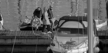 İtalya, Sicilya, Akdeniz, Marina di Ragusa (Ragusa ili); 22 Şubat 2025, limandaki insanlar, motorlu tekneler ve lüks yatlar - EDITORIAL