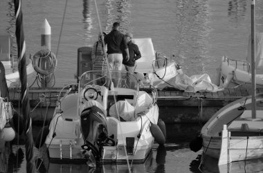 İtalya, Sicilya, Akdeniz, Marina di Ragusa (Ragusa ili); 22 Şubat 2025, limandaki insanlar, motorlu tekneler ve lüks yatlar - EDITORIAL