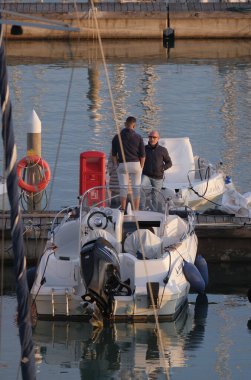 İtalya, Sicilya, Akdeniz, Marina di Ragusa (Ragusa ili); 22 Şubat 2025, limandaki insanlar, motorlu tekneler ve lüks yatlar - EDITORIAL