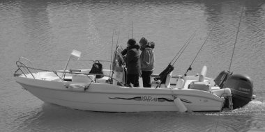 İtalya, Sicilya, Akdeniz, Marina di Ragusa (Ragusa Eyaleti); 23 Şubat 2025, limandaki bir motorlu teknede balıkçı - EDITORIAL