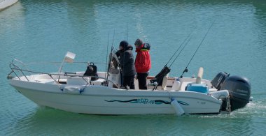 İtalya, Sicilya, Akdeniz, Marina di Ragusa (Ragusa Eyaleti); 23 Şubat 2025, limandaki bir motorlu teknede balıkçı - EDITORIAL