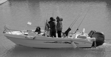 İtalya, Sicilya, Akdeniz, Marina di Ragusa (Ragusa Eyaleti); 23 Şubat 2025, limandaki bir motorlu teknede balıkçı - EDITORIAL