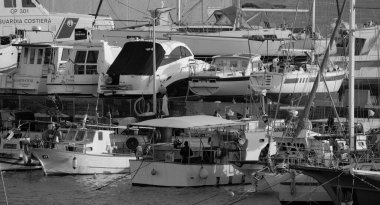 İtalya, Sicilya, Marina di Ragusa (Ragusa Eyaleti); 1 Mart 2025, limanda yerel balıkçı tekneleri ve lüks yatlar - EDITORIAL