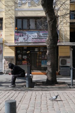 Bulgaristan, Sofya; 9 Mart 2025, kentin orta sokağındaki bir bankta oturan Bulgar adam - EDITORIAL