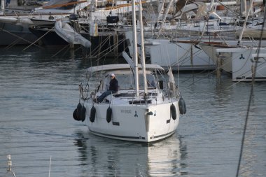 İtalya, Sicilya, Akdeniz, Marina di Ragusa (Ragusa ili); 3 Nisan 2025, limandaki bir yelkenli teknesinde insanlar - EDITORIAL