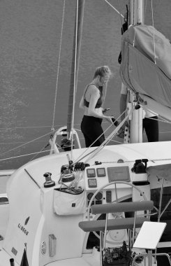 İtalya, Sicilya, Akdeniz, Marina di Ragusa (Ragusa Eyaleti); 28 Nisan 2025, limanda bir katamaran yelkenli teknesinde çift - EDITORIAL