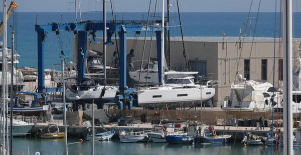 İtalya, Sicilya, Marina di Ragusa (Ragusa Eyaleti); 30 Nisan 2025, limanda yerel balıkçı tekneleri ve lüks yatlar - EDITORIAL