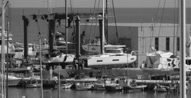 İtalya, Sicilya, Marina di Ragusa (Ragusa Eyaleti); 30 Nisan 2025, limanda yerel balıkçı tekneleri ve lüks yatlar - EDITORIAL