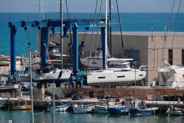 İtalya, Sicilya, Marina di Ragusa (Ragusa Eyaleti); 30 Nisan 2025, limanda yerel balıkçı tekneleri ve lüks yatlar - EDITORIAL