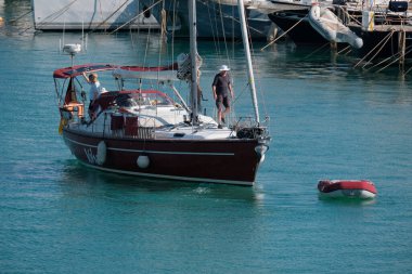 İtalya, Sicilya, Akdeniz, Marina di Ragusa (Ragusa Eyaleti); 30 Nisan 2025, limandaki bir yelkenli ve lüks yatlarda yaşayan insanlar - EDITORIAL