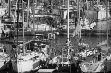 İtalya, Sicilya, Akdeniz, Marina di Ragusa (Ragusa Eyaleti); 30 Nisan 2025, limandaki bir yelkenli ve lüks yatlarda yaşayan insanlar - EDITORIAL