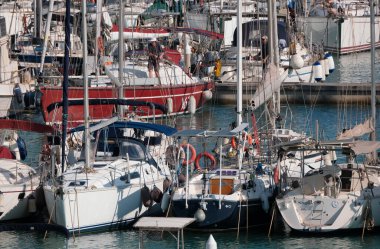 İtalya, Sicilya, Akdeniz, Marina di Ragusa (Ragusa Eyaleti); 30 Nisan 2025, limandaki bir yelkenli ve lüks yatlarda yaşayan insanlar - EDITORIAL