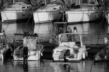 İtalya, Sicilya, Akdeniz, Marina di Ragusa (Ragusa Eyaleti); 2 Mayıs 2025, limandaki insanlar, motorlu tekneler ve lüks yatlar - EDITORIAL