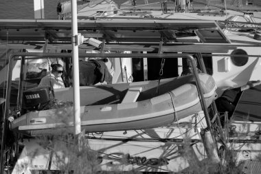 İtalya, Sicilya, Akdeniz, Marina di Ragusa (Ragusa Eyaleti); 3 Mayıs 2025, limandaki bir katamaran yelkenli teknesinde çift - EDITORIAL