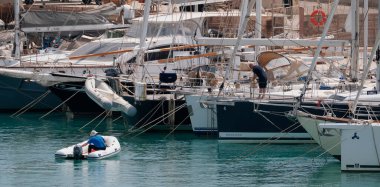 İtalya, Sicilya, Akdeniz, Marina di Ragusa (Ragusa Eyaleti); 4 Mayıs 2025, limandaki insanlar ve lüks yatlar - EDITORIAL