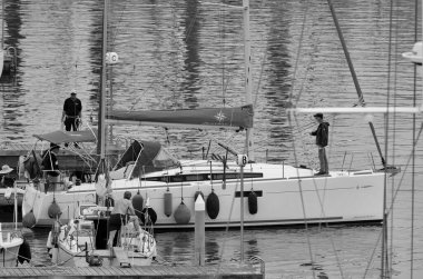 İtalya, Sicilya, Akdeniz, Marina di Ragusa (Ragusa Eyaleti); 4 Mayıs 2025, limandaki bir yelkenli ve lüks yatlarda erkekler - EDITORIAL