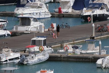 İtalya, Sicilya, Akdeniz, Marina di Ragusa (Ragusa Eyaleti); 6 Mayıs 2025, limandaki insanlar, motorlu tekneler ve lüks yatlar - EDITORIAL