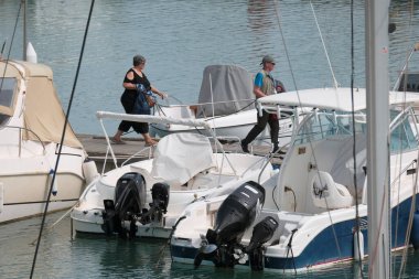 İtalya, Sicilya, Akdeniz, Marina di Ragusa (Ragusa ili); 10 Mayıs 2025, limandaki insanlar, motorlu tekneler ve lüks yatlar - EDITORIAL