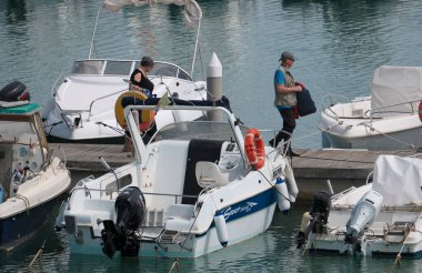 İtalya, Sicilya, Akdeniz, Marina di Ragusa (Ragusa ili); 10 Mayıs 2025, limandaki insanlar, motorlu tekneler ve lüks yatlar - EDITORIAL