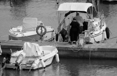 İtalya, Sicilya, Akdeniz, Marina di Ragusa (Ragusa ili); 10 Mayıs 2025, limandaki insanlar, motorlu tekneler ve lüks yatlar - EDITORIAL