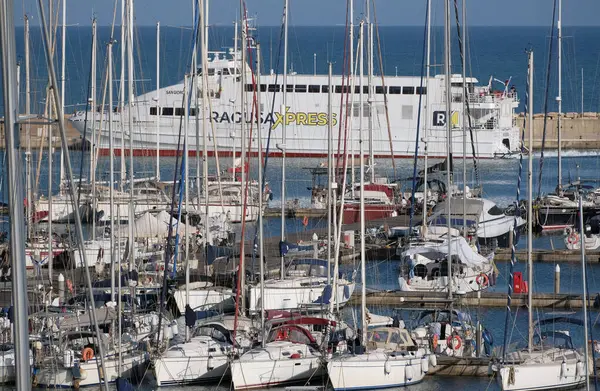 İtalya, Sicilya, Akdeniz, Marina di Ragusa (Ragusa ili); 13 Mayıs 2025, Sicilya 'yı Malta adasına bağlayan feribot ve limandaki lüks yatlar - EDITORIAL
