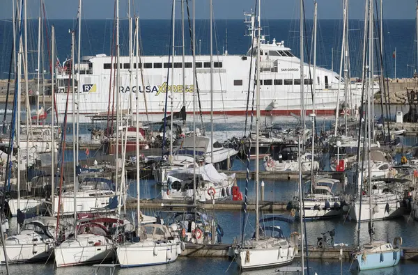 İtalya, Sicilya, Akdeniz, Marina di Ragusa (Ragusa ili); 13 Mayıs 2025, Sicilya 'yı Malta adasına bağlayan feribot ve limandaki lüks yatlar - EDITORIAL