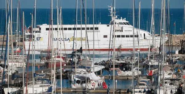 İtalya, Sicilya, Akdeniz, Marina di Ragusa (Ragusa ili); 13 Mayıs 2025, Sicilya 'yı Malta adasına bağlayan feribot ve limandaki lüks yatlar - EDITORIAL
