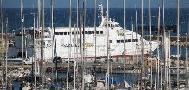 İtalya, Sicilya, Akdeniz, Marina di Ragusa (Ragusa ili); 13 Mayıs 2025, Sicilya 'yı Malta adasına bağlayan feribot ve limandaki lüks yatlar - EDITORIAL